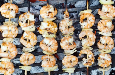 Skewers of shrimp and onions over hot coals
